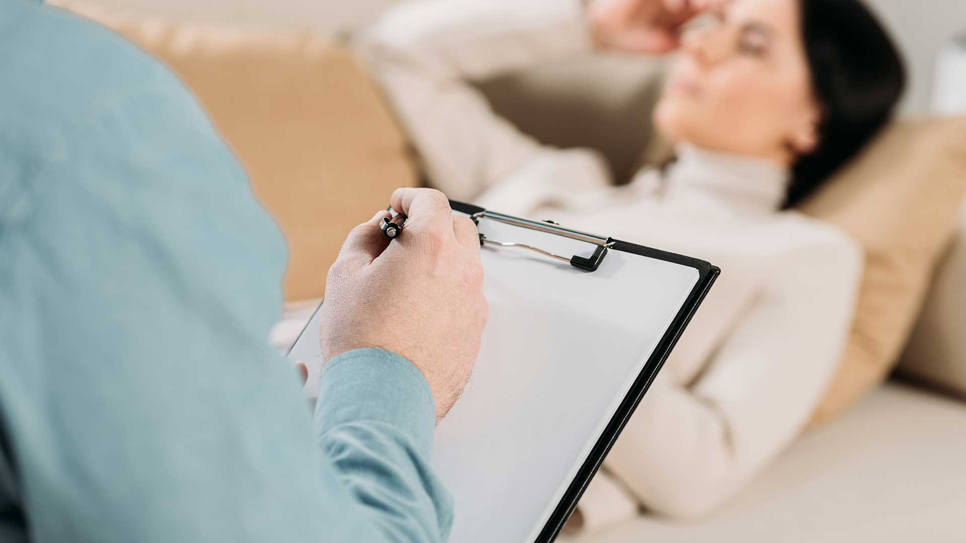 woman-on-couch-doctor-in-blue-shirt-writing-vanguard-psychiatry